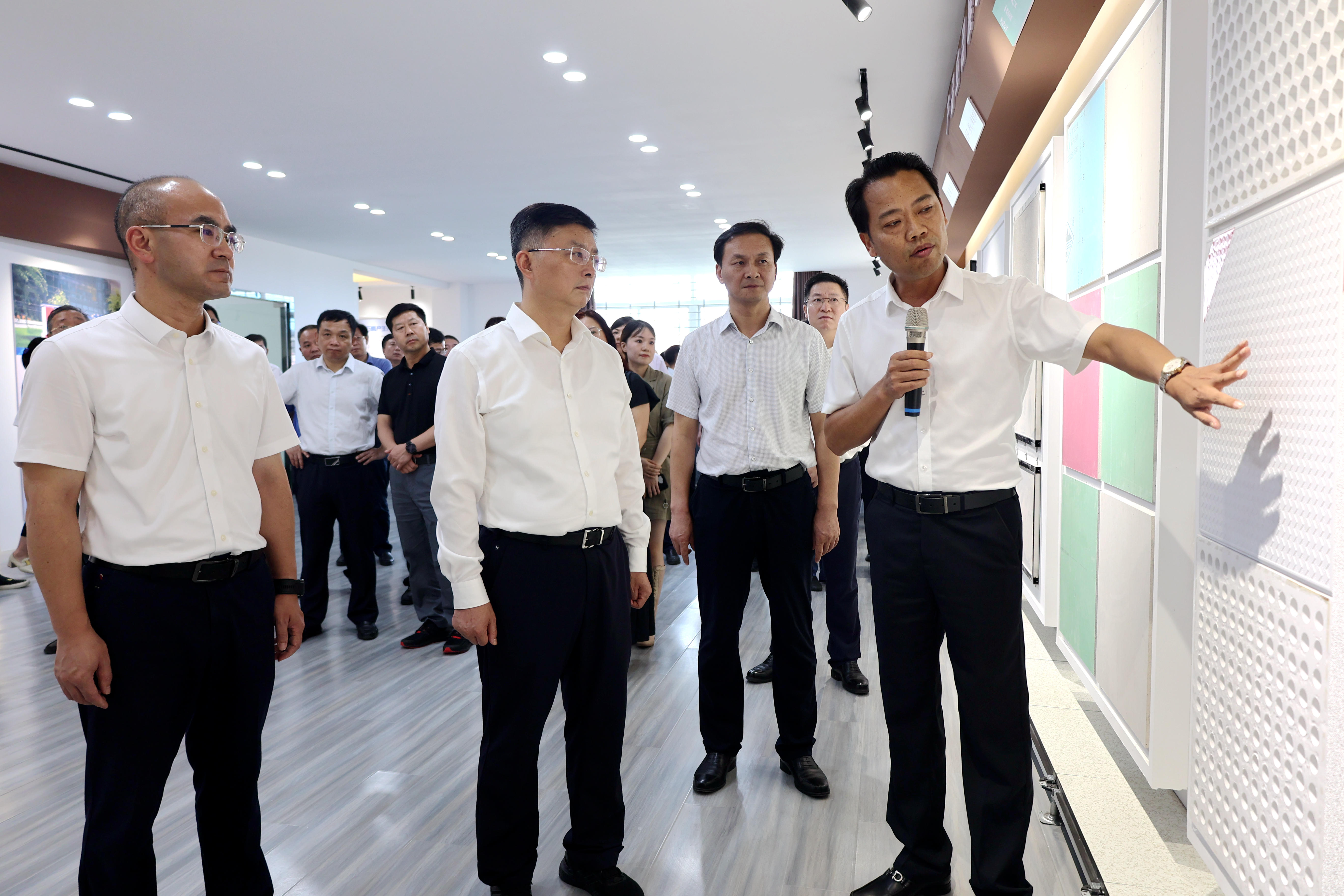 李维峰（前排右）正在向李涛（前排中）、江稳（前排左）等领导介绍磷石膏制各类产品.jpg
